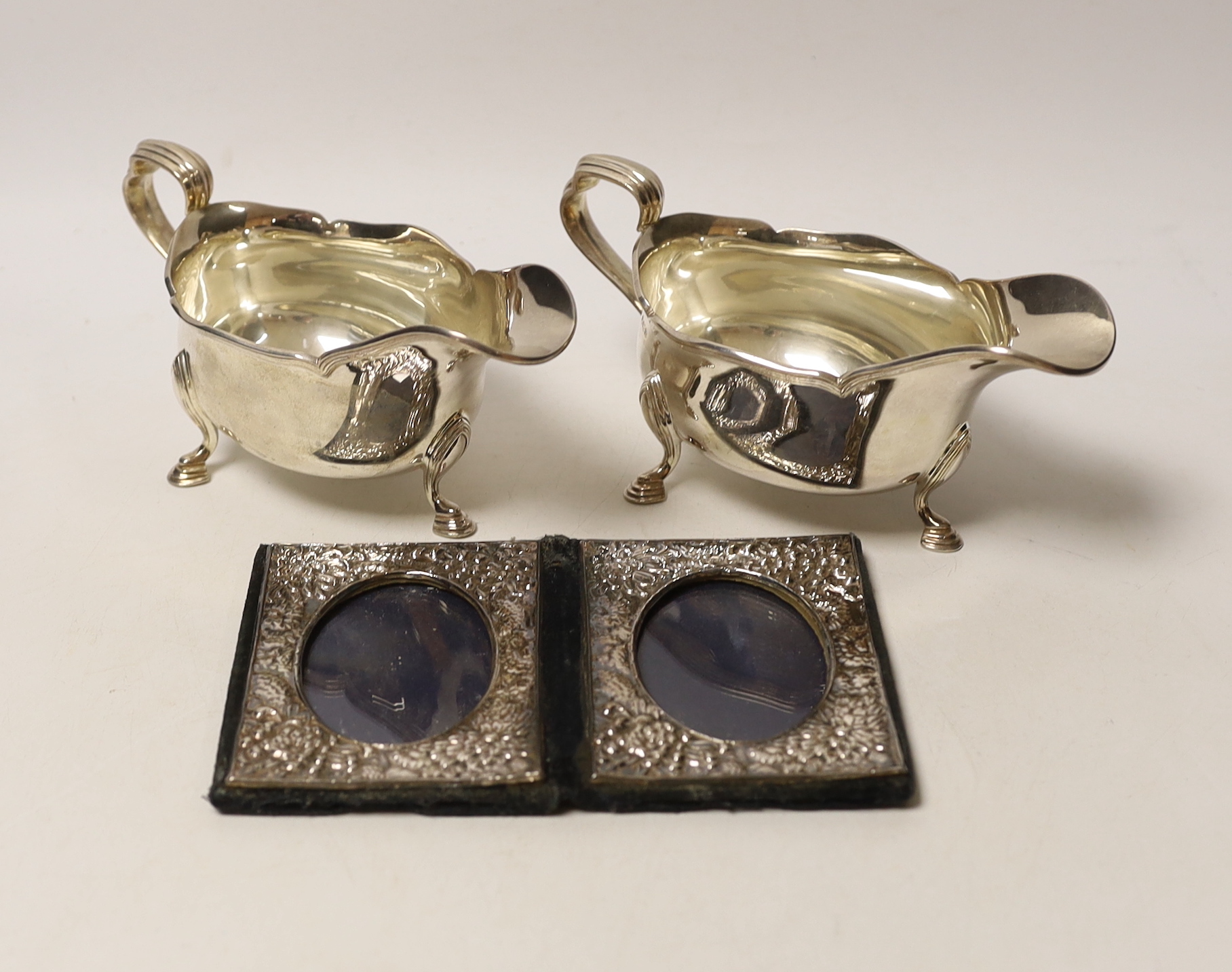 A pair of George V silver sauce boats, Atkin Brothers, Sheffield, 1927, 15.1oz, together with a modern silver mounted double photograph frame.